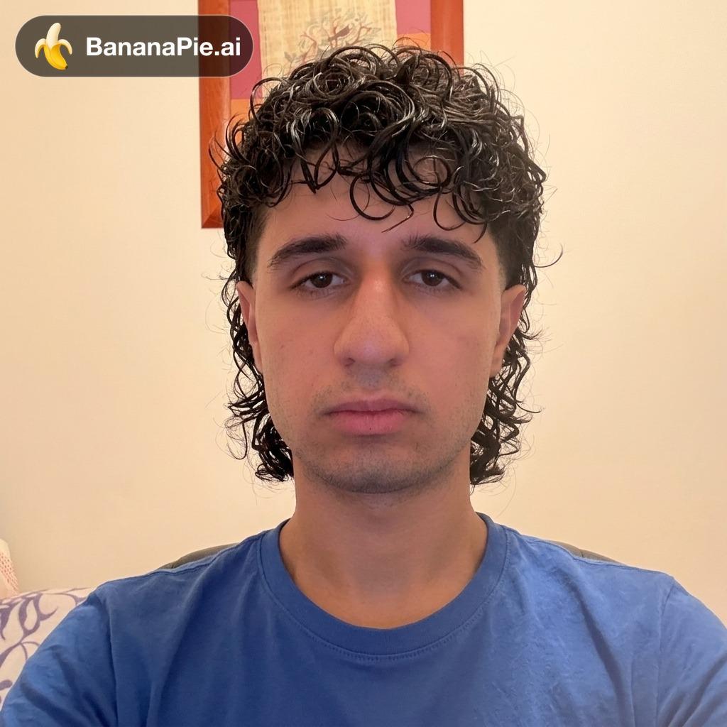 Modern messy curly mullet haircut, styled with defined natural wet-look curls on top and cascading layers down the back of the neck. Clean low taper fade on the sides above the ears, blending into voluminous curly texture. The hair should look naturally textured, wavy-to-curly, with dynamic volume and a casual, contemporary aesthetic, exactly matching the hairstyle from the reference look.