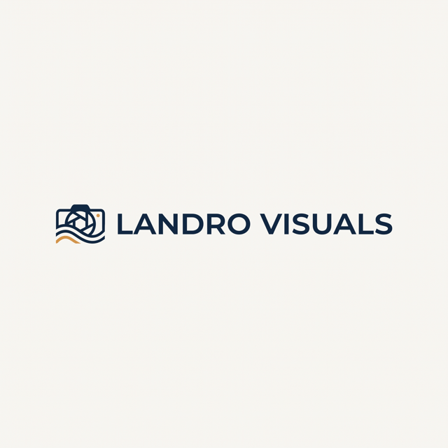 "Minimalist logo for a visual design studio called Landro Visuals, clean sans-serif wordmark with a subtle geometric accent, deep navy and warm amber on a soft off-white background, modern Scandinavian style, flat vector, high contrast, professional, no gradients, no shadows, centered composition, suitable for a website header with a small abstract mark combining a camera lens and a wave, placed to the left of the wordmark."