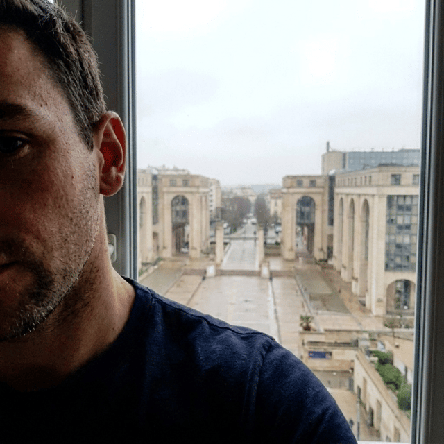 Modifie la photo, on ne doit pas voir le smartphone, mais juste une partie du visage mal cadrée. La photo est prise en mode selfie. On ne doit pas voir le logo Mercure car la photo est prise depuis la fenêtre de l'hotel Mercure;