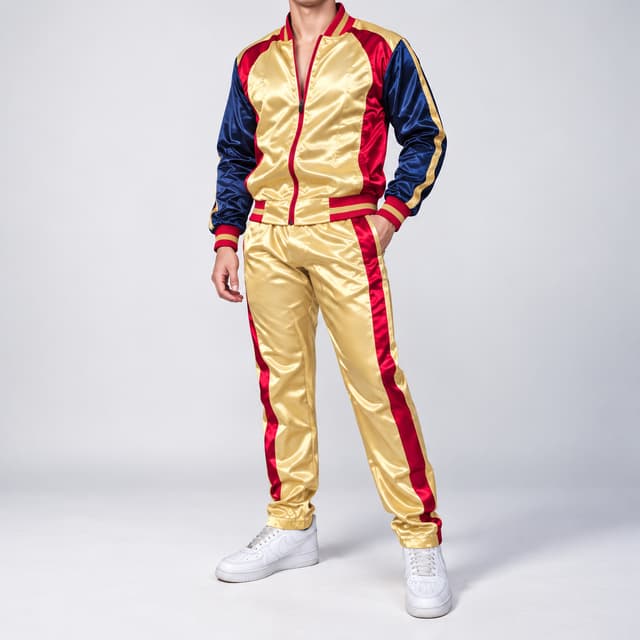A premium, high-gloss satin track suit (2-piece jacket and pants set) in deep gold and navy blue with vibrant red accents[cite: 4]. The jacket body is brilliant gold satin, featuring contrasting navy blue sleeves with continuous gold and navy raglan stripes down the arms[cite: 4]. The front full zipper, ribbed stand-up collar, wrist cuffs, and bottom hem are lined with a distinct bold red stripe trim[cite: 4]. The matching pants are brilliant gold satin with continuous bold red side stripes down each leg, front pockets, and an elasticated waist[cite: 4].A professional studio portrait shot with clean, soft, even studio lighting. The background is a flawless, seamless neutral white studio wall. The male model is in a relaxed standing pose, three-quarter profile, with one hand casually placed in the front pants pocket and the other slightly bent, showcasing the drape and high sheen of the gold satin fabric. He is wearing clean, classic white sports sneakers[cite: 4]. **Crucially, the frame is tightly cropped at the base of the neck, revealing the model's neck and chin, but fully removing the face, eyes, and top of the head for a sophisticated and anonymized presentation.** He is wearing classic white sports sneakers. The focus is sharp on the satin details and stripe patterns.low resolution, low quality, pixelated, blurry, out of focus, distorted, artifacted, jagged edges, compressed, dull fabric, matte fabric, modifications to the design, full face visible, eyes visible, top of head visible, hair, facial expression, different fabric type, added logos, missing red side stripes, incorrect fit, incorrect colors (outside of gold, navy, red, white).